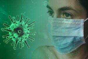 Eine Frau mit Gesichtsmaske vor einem grünen Coronavirus.