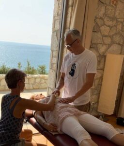 Eine Frau genießt eine Massage mit Blick auf den ruhigen Blick auf das Meer.
