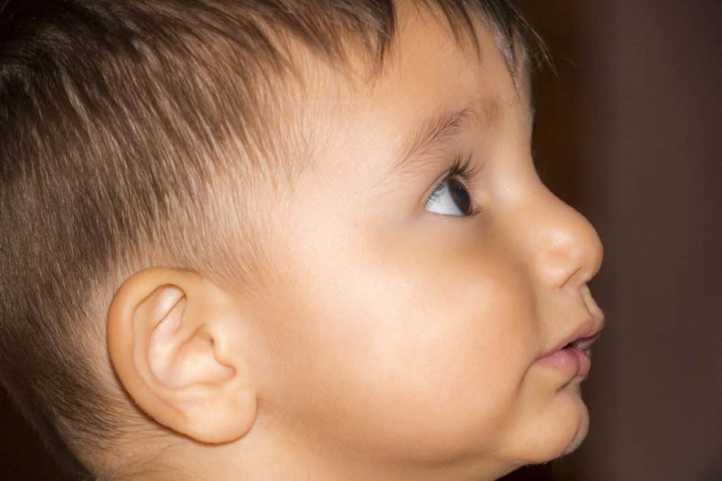 Eine Nahaufnahme eines kleinen Jungen mit Sportosteopathie, der nach oben schaut.