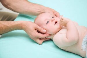 Ein Baby wird in Hamburg von einem Osteopathen untersucht.