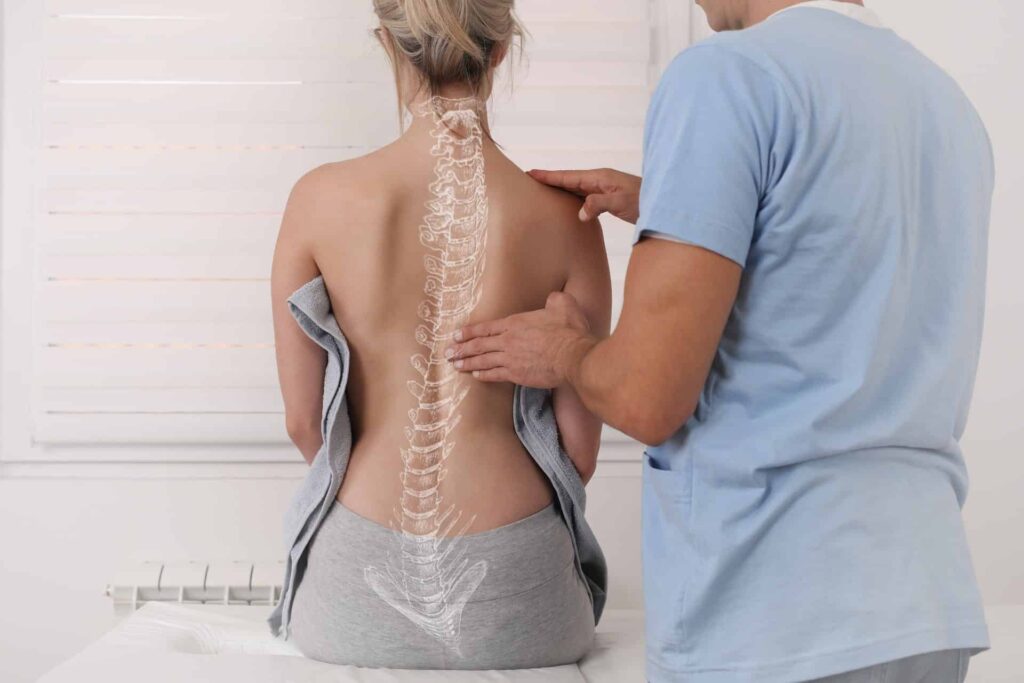 Eine Frau lässt ihren Rücken von einem Osteopathen Hamburg untersuchen.