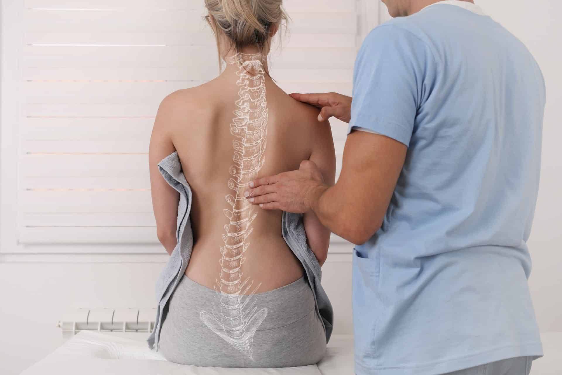 Eine Frau lässt ihren Rücken von einem Osteopathen Hamburg untersuchen.
